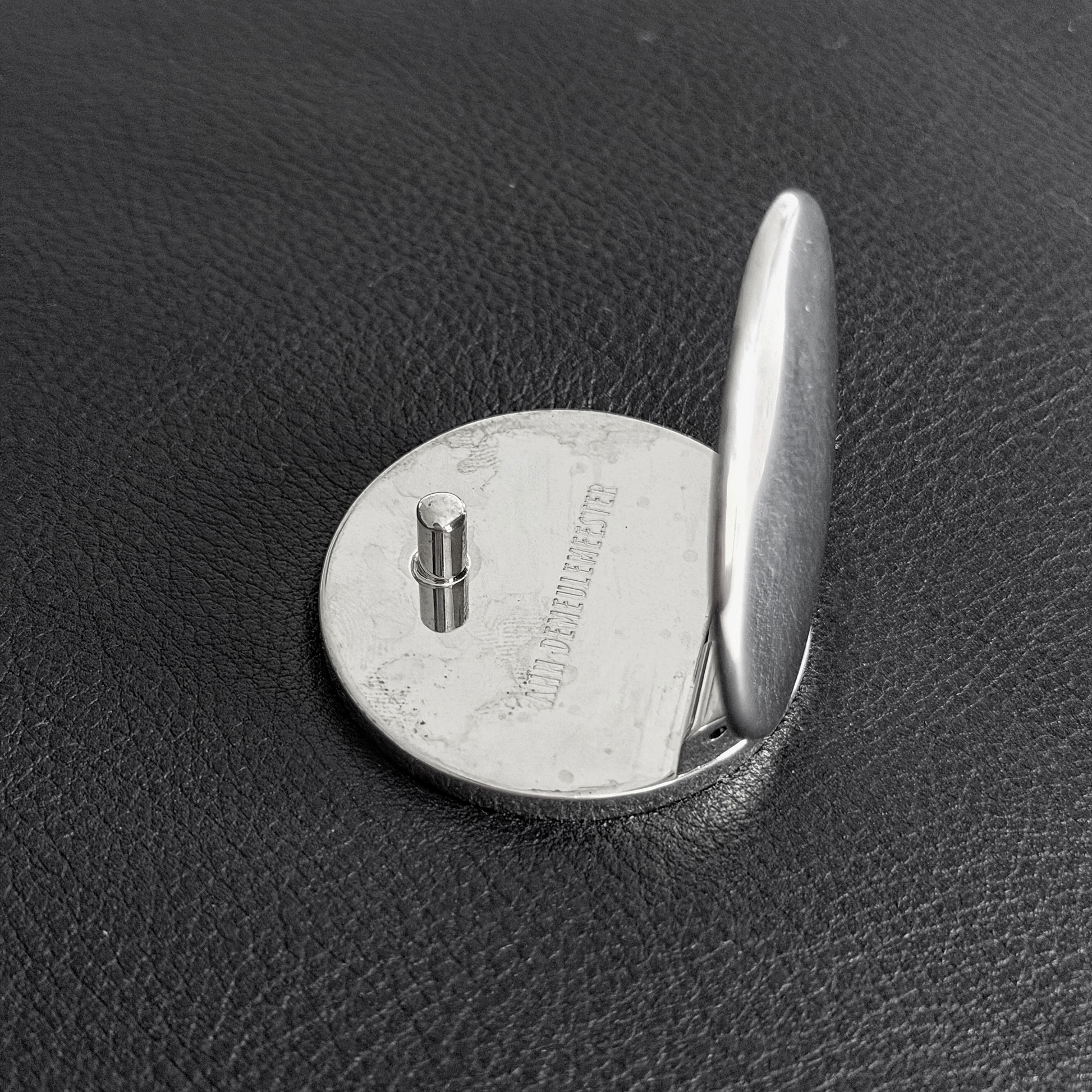Silver-tone closure engraved with Ann Demeulemeester branding on black leather