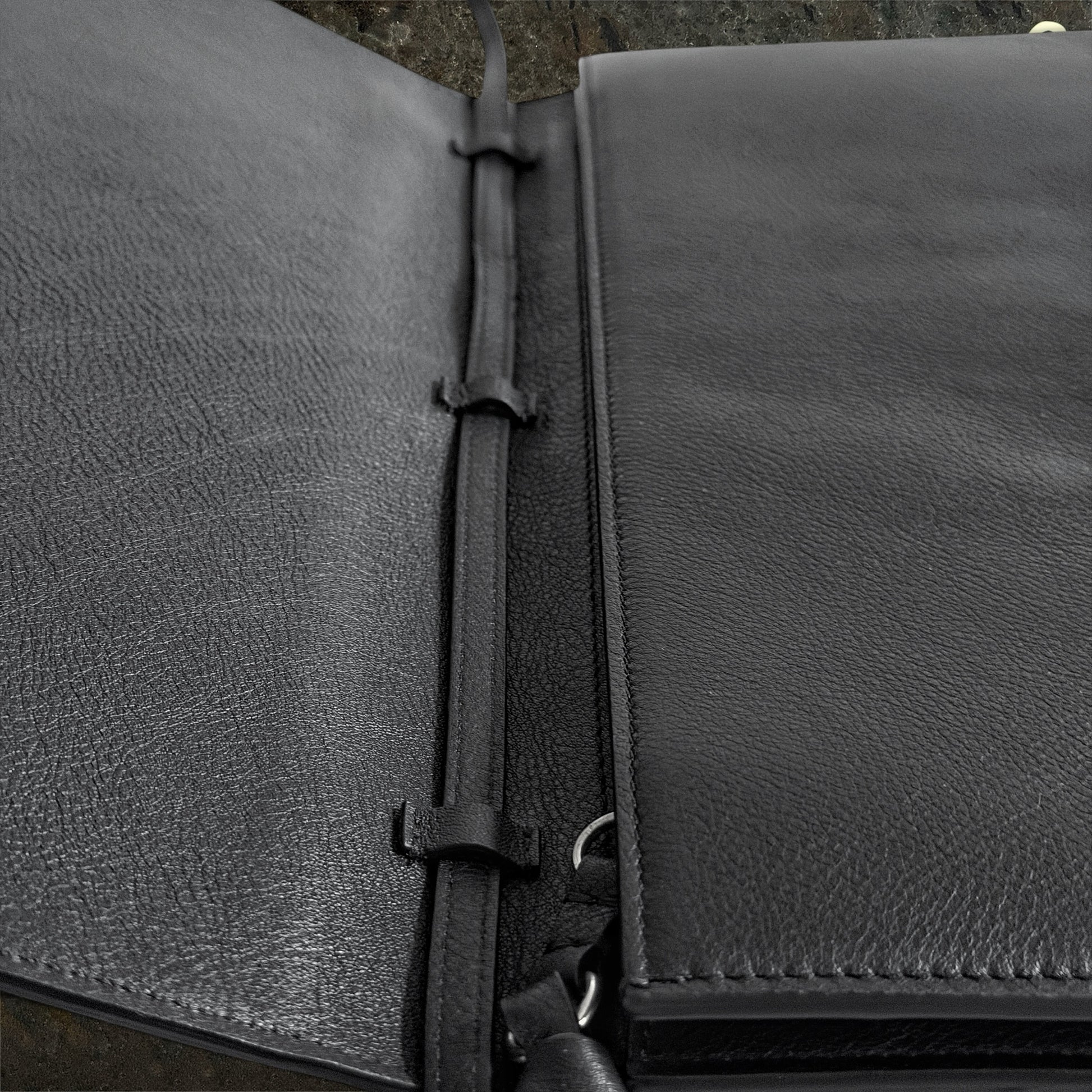 Close-up of full-grain black leather and stitched strap on Ann Demeulemeester bag