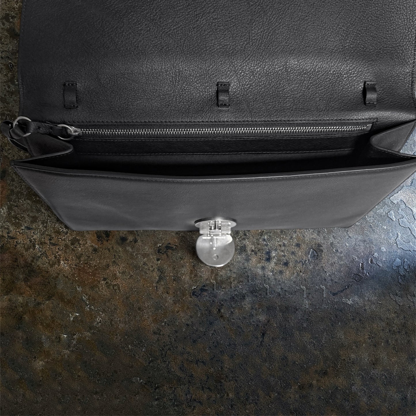 Interior of Ann Demeulemeester shoulder bag with zipped pocket and closure detail